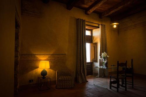 a room with a lamp and a chair and a window at Castello di Rocca Cilento in Rocca Cilento