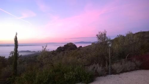 a view of a hill with the sunset in the background at Piccolo Relais Galletto di Marzo Spa e relax solo per due in Paciano