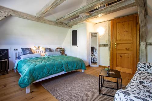 a bedroom with a green bed and a couch at Ferienwohnung am Schlossgarten in Schmieheim