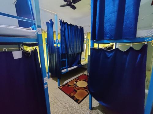 a room with blue walls and blue curtains at The Lost Hostel, Varkala - Helipad in Varkala