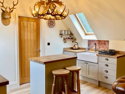 a kitchen with a chandelier and a counter and stools at TreeTops in Barlow