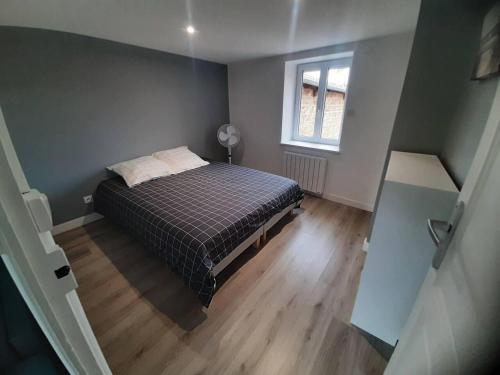 Bel Appartement T2 40 M2 في Vaugneray: غرفة نوم صغيرة بها سرير ونافذة