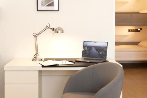 a laptop computer sitting on a desk with a chair at Woohoo Rooms Boutique Gran Vía in Madrid