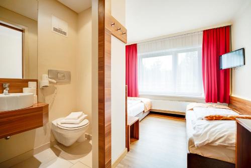 two pictures of a bathroom with a sink and a toilet at Hotel Astoria in Salzburg