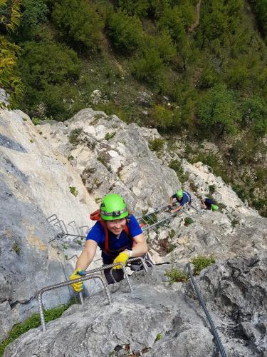 a person in a green helmet climbing on a mountain at Sveri Adventure Camp in Chiatʼura