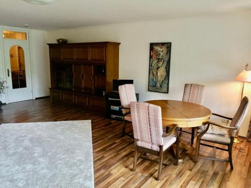 een woonkamer met een houten tafel en stoelen bij Spacious Roof Top Maisonett Apartment in PRIEN at Lake Chiemsee in Stock