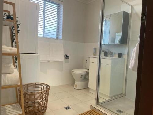 a bathroom with a toilet and a glass shower at Beach Retreat in Henley Beach South