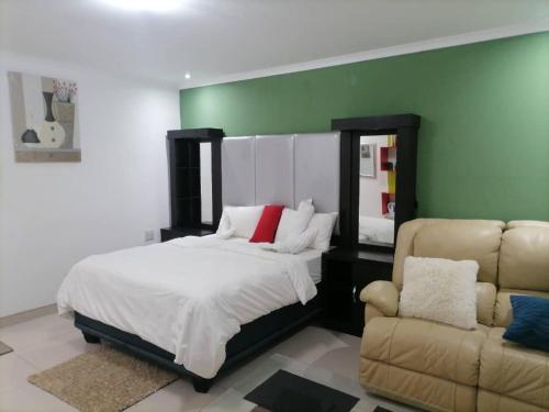 1 dormitorio con 1 cama, 1 sofá y 1 silla en Royal guesthouse, en Opuwo