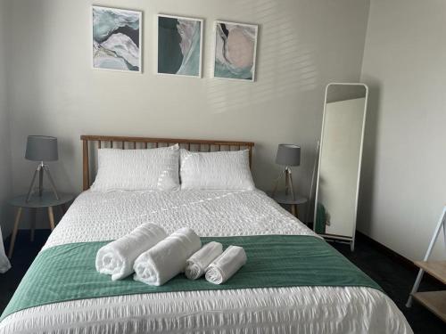 a bedroom with a bed with four towels on it at Beach Retreat in Henley Beach South