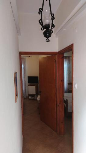 a hallway with a door and a chandelier at Hotel Evripides in Agios Ioannis Pelio