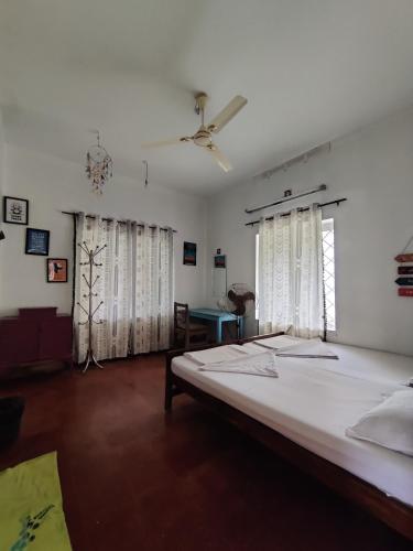 a bedroom with a large bed and a ceiling fan at Hope Hostels, Varkala - Helipad in Varkala