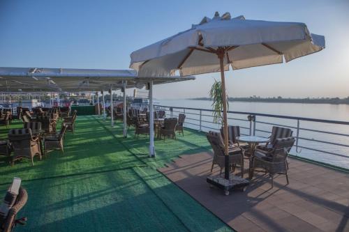 a patio with chairs and tables and an umbrella at M/S Royal Adventure - Saturday from Luxor 4 or 7 Nights - Wednesday from Aswan 3 or 7 Nights in Luxor