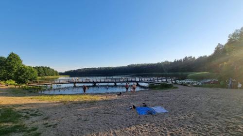 a group of people on a beach with a pier at Domek "U Pszczelarza" in Golub-Dobrzyń