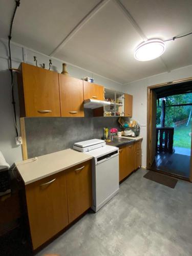 a kitchen with wooden cabinets and a white stove top oven at Domek "U Pszczelarza" in Golub-Dobrzyń