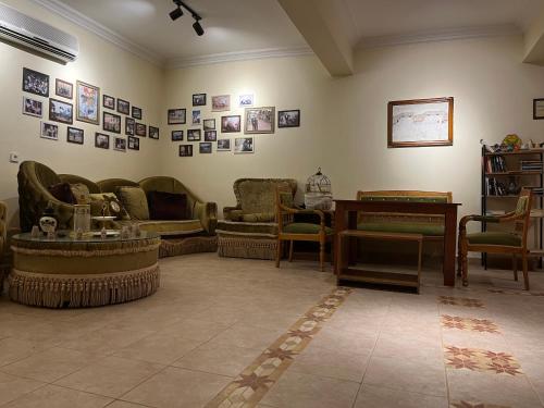 a living room with couches and tables and pictures on the wall at Hotel Euphrat Nemrut in Karadut