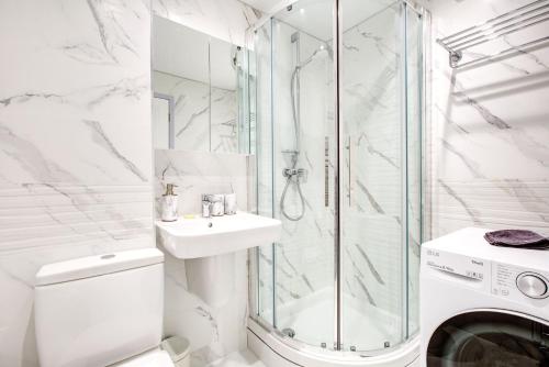 a white bathroom with a shower and a washing machine at 2 bedroom luxury House in Oxford in Oxford