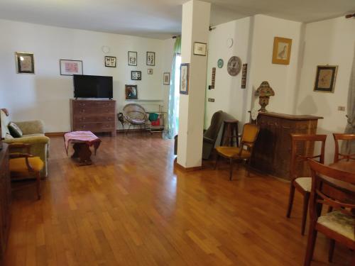 a living room with a hard wood floor and a tv at Attico in Pitigliano