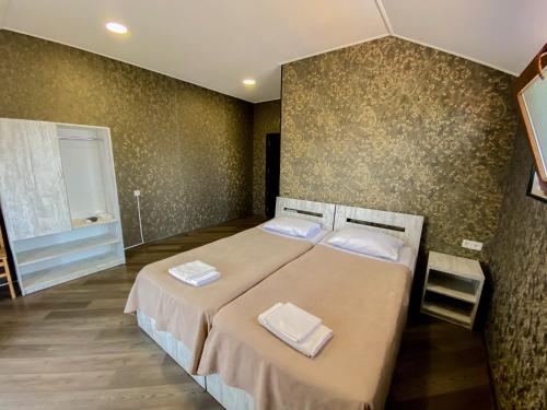 een slaapkamer met een bed met twee handdoeken erop bij Chateau ikalto in Ikalto