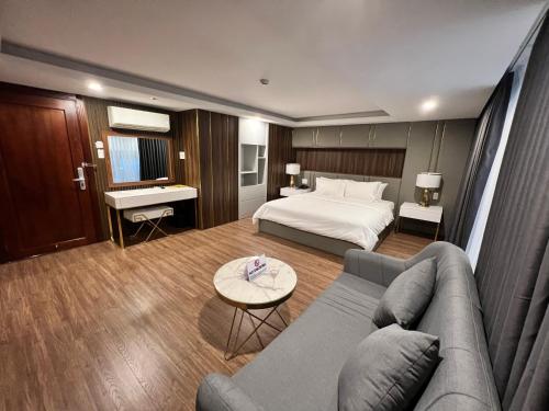 胡志明市的住宿－Nam Hy 1 Hotel，酒店客房,配有床和沙发