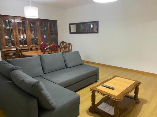 a living room with a blue couch and a table at Congidouro in Freixo de Espada à Cinta