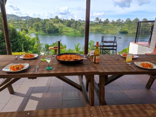 - une table en bois avec des assiettes de nourriture et de boissons dans l'établissement La Villa, Espectaculares vistas al lago Peñol-Guatape, à Guatapé