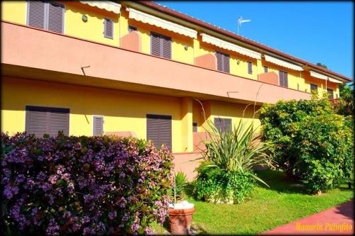 a yellow building with purple flowers in front of it at Hotel Anfora in Capoliveri