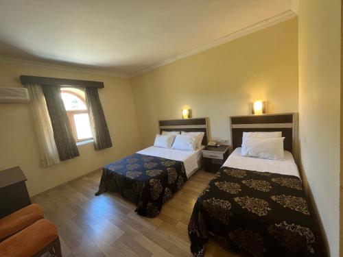 um quarto de hotel com duas camas e uma janela em Hotel Euphrat Nemrut em Karadut