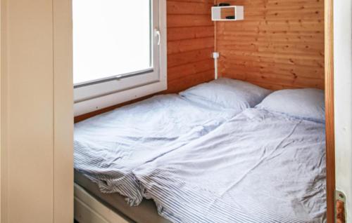 an unmade bed in a room with a window at Stunning Ship In Brandenburg With Lake View in Kützkow