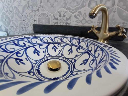 a blue and white sink with a gold faucet at Casa de las Nieves in Pitres