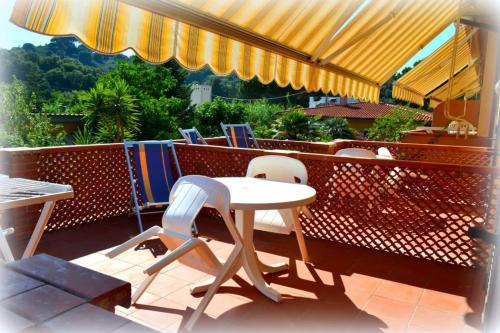 a patio with a table and chairs on a balcony at Hotel Anfora in Capoliveri