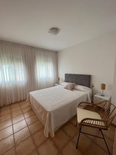 1 dormitorio con 1 cama grande y 1 silla en Apartaments Marinera, en L'Eucaliptus