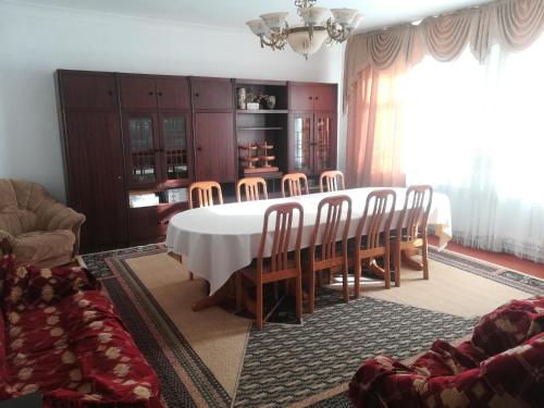 a dining room with a white table and chairs at Guest house Liliya in Kochkor
