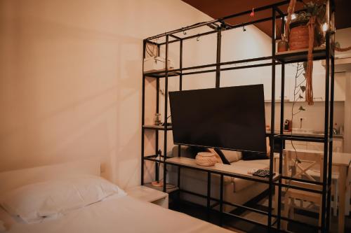 een slaapkamer met een bed en een computermonitor op een plank bij Apartman Tilia in Mostar