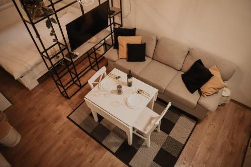 een woonkamer met een witte tafel en een bank bij Apartman Tilia in Mostar