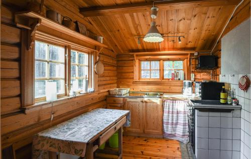 Cabaña con cocina con paredes de madera y suelo de madera. en 2 Bedroom Amazing Home In Mora-nuns, 