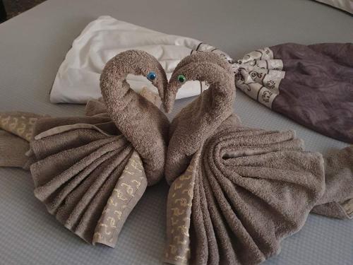 two towel swans sitting on top of a bed at Vila Theo in Mangalia