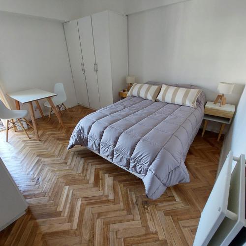 una camera con un grande letto e un pavimento in legno di SOHO PETIT STUDIO - EXCELENTE UBICACIÓN - Súper cómodo, completo - PALERMO a Buenos Aires