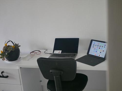 a desk with two laptops and a chair on it at Villa Kikiriki in Kigali