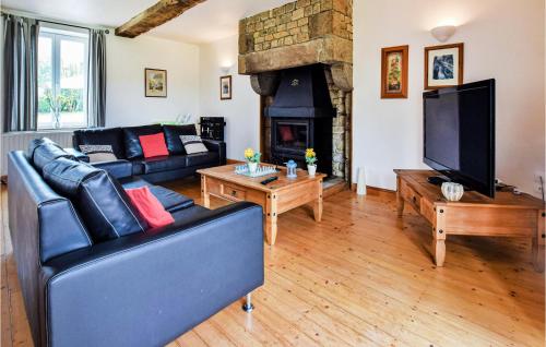 a living room with a couch and a fireplace at Lovely Home In Vire Normandie With Wifi in Saint-Martin-de-Tallevende