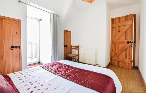 1 dormitorio con 1 cama y puerta de madera en Beautiful Home In Vire Normandie With Lake View 