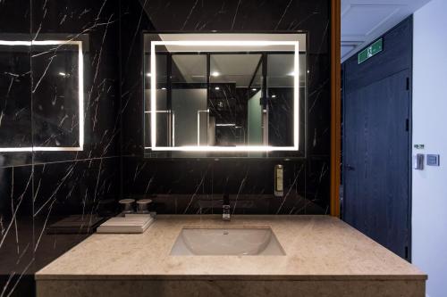 y baño con lavabo y espejo. en The Club Hotel Gijang Yeonhwari en Busan