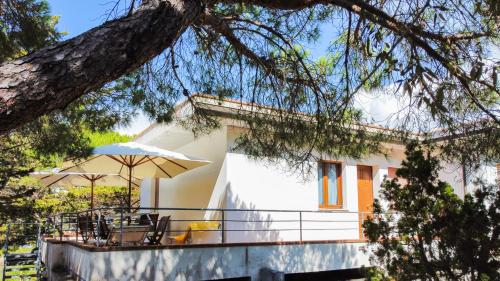 a house with a balcony with an umbrella at Villa Verde in Procchio