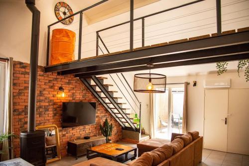 ein Wohnzimmer mit einem Sofa und einem Loft in der Unterkunft Loft Évasion - Garage & Spa proche du centre historique in Avignon