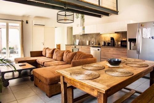 a kitchen and living room with a wooden table at Loft 90 m2 cosy au calme avec terrasse et parking in Avignon