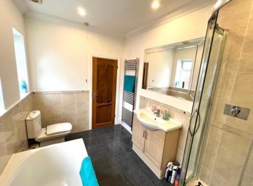 a bathroom with a tub and a sink and a shower at Sunrise in Poole