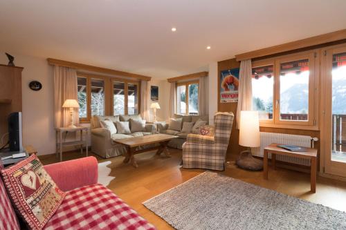 a living room with a couch and a table at Chalet Eigersunne 2 in Wengen