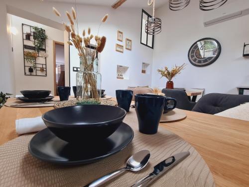 a wooden table with a black bowl on top of it at La suite Mélusine - SPA du Souffle du Saule in Buhl-Lorraine