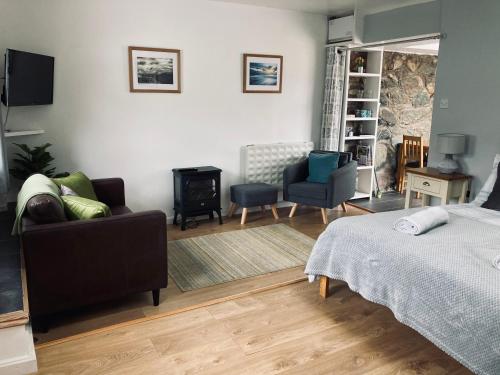 a bedroom with a bed and a living room at Stiwdio Eithinog in Caernarfon