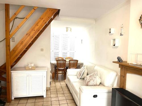 een woonkamer met een witte bank en een tafel bij Chez’ Elle in Blankenberge
