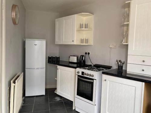 y cocina con fogones blancos y nevera. en Cozy 2-bedroom property with shared garden, en Sunderland